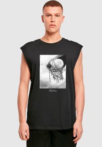 Svart ermeløs T-skjorte laget av bomull. Den har et sentralt design av en basketballkurv og nett i monokrom utførelse, med teksten "Ballin".