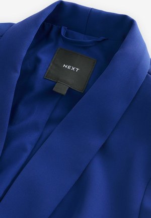 Blue blazer with a smooth, textured fabric; features a notched collar and a black label with "NEXT" in white.