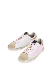 Zapatillas blancas y beige con detalles de purpurina rosa. Presentan una puntera redonda, cordones en tono rubor y una textura suave de ante en la puntera.