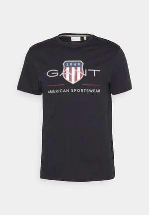 Zwarte katoenen T-shirt met ronde hals, korte mouwen en een grafisch ontwerp met een schildlogo, gestreepte accenten en de tekst "GANT AMERICAN SPORTSWEAR."