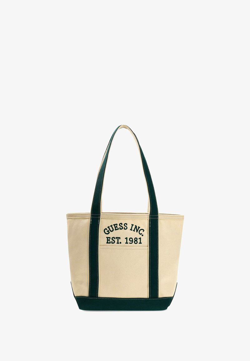 Beżowa torba typu tote z ciemnozielonymi uchwytami i akcentami. Na przodzie wyszyte "GUESS INC. EST. 1981". Kształt wiadra, średni rozmiar.