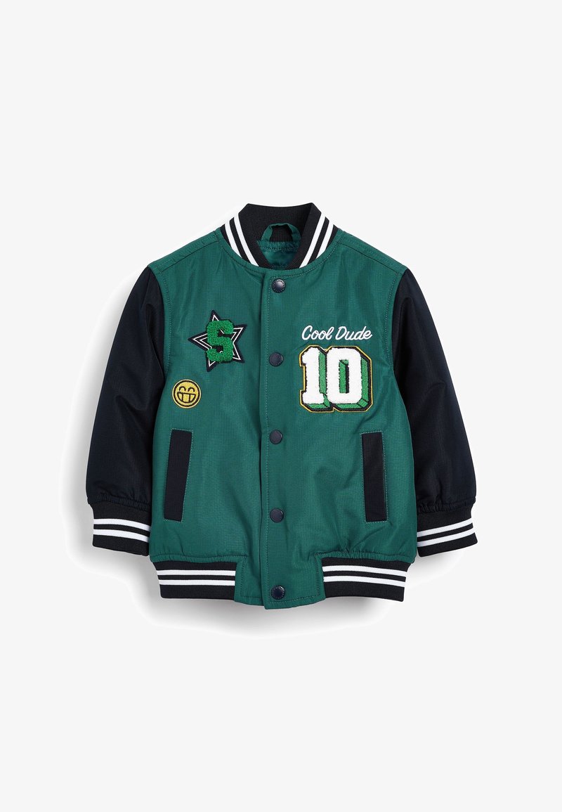 Veste universitaire verte et noire avec le texte "Cool Dude", écusson numéro 10, écusson étoile "S" vert, et emblème de visage souriant sur le devant.