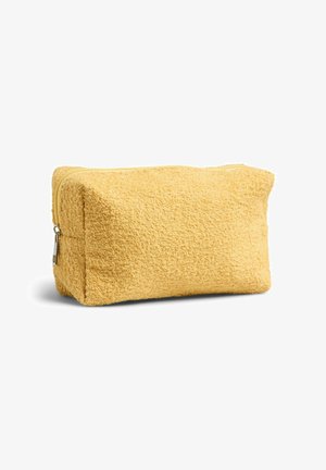 Trousse de toilette rectangulaire jaune douce avec tissu texturé et fermeture éclair en haut sur fond blanc.