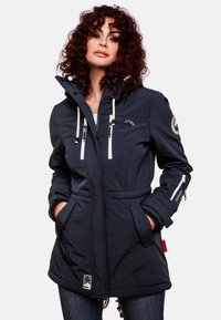 Navy blue jacket with a zip-up front, drawstring hood, two front pockets, and white accents. Features logo patch on the sleeve.