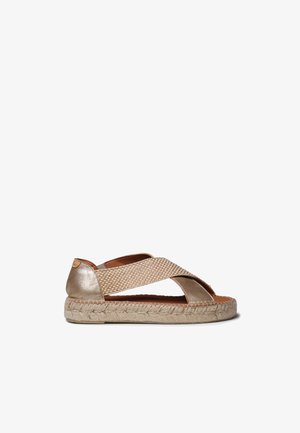 Sandale espadrille beige avec lanières croisées tissées, talon métallique et semelle en jute tressé, conçue pour un usage décontracté.