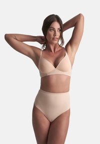 Beige trådlös bh med en jämn, mjuk textur och trekantskupor, tillsammans med höga trosor, båda i en sömlös, minimalistisk design.