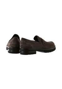 Bruna mockaläder loafers med låg gummisula, rund tå och dekorativ sömnad. Funktioner inkluderar en slip-on-design och subtil dämpning.