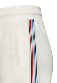 Weiße Jogginghosen mit einem gerippten Bund, Seitentasche und einem vertikalen Streifenmuster in Rot, Blau und Beige. Weicher Stoff.