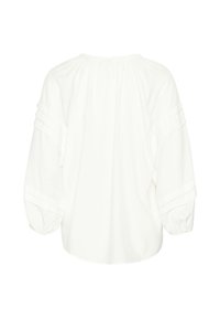 Blusa bianca a maniche lunghe con scollatura arricciata, maniche volumetriche e pieghe verticali sulle spalle. Tessuto di cotone morbido.