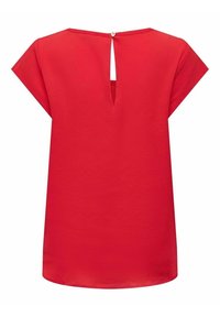 Blouse rouge à manches courtes en tissu texturé, avec une ouverture en forme de trou de serrure dans le dos, fermée par un bouton unique au niveau de l'encolure.