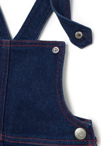 Jeanslatzhosen bestehen aus dunkelblauem Stoff, roten Nähten und silbernem Zubehör an den Trägern mit Druckknöpfen zur Anpassung.