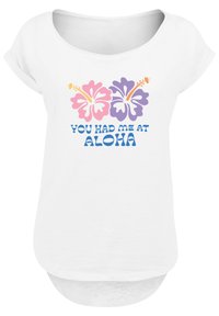 Weißes Kurzarmhemd mit pinken und lila Hibiskusblumen sowie dem Text "DU HAST MICH MIT ALOHA BEGEISTERT" in Blau. Weicher Stoff und abgerundeter Saum.