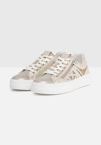 Zapatillas metálicas beige con acentos texturizados, suela de plataforma blanca, cierre con cordones y cremalleras laterales con detalles de purpurina.