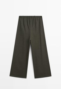 Pantaloni ampi di colore verde scuro con vita elasticizzata. Il tessuto sembra morbido, con una texture opaca e senza motivi o decorazioni visibili.