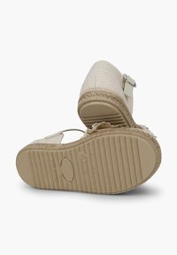 Béžové espadrilky se tkanou texturou, kulatou špičkou, pásem kolem kotníku a jutovými detaily. Odolná gumová podrážka s drážkami.