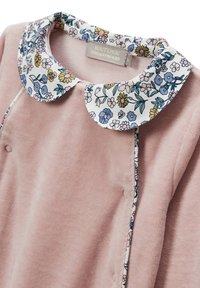 Robe en velours rose avec un col à imprimé floral, présentant des fleurs bleues et jaunes. Comprend des détails de boutons le long de la couture avant.