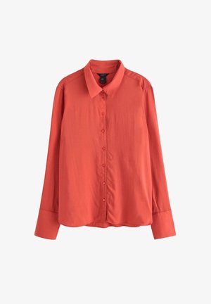 Röd långärmad skjorta gjord av slätt tyg med knappframsida, klassisk krage och rakt skuren nederkant. Har matchande knappar.