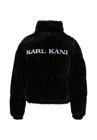 Black velvet puffer jacket with a high collar, ribbed texture, and white "KARL KANI" embroidery across the back.