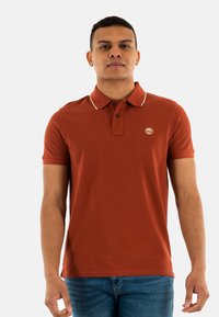 Polo rustico con colletto a contrasto, due bottoni e un piccolo logo. Realizzato in morbido cotone, presenta maniche corte e una forma fitted.