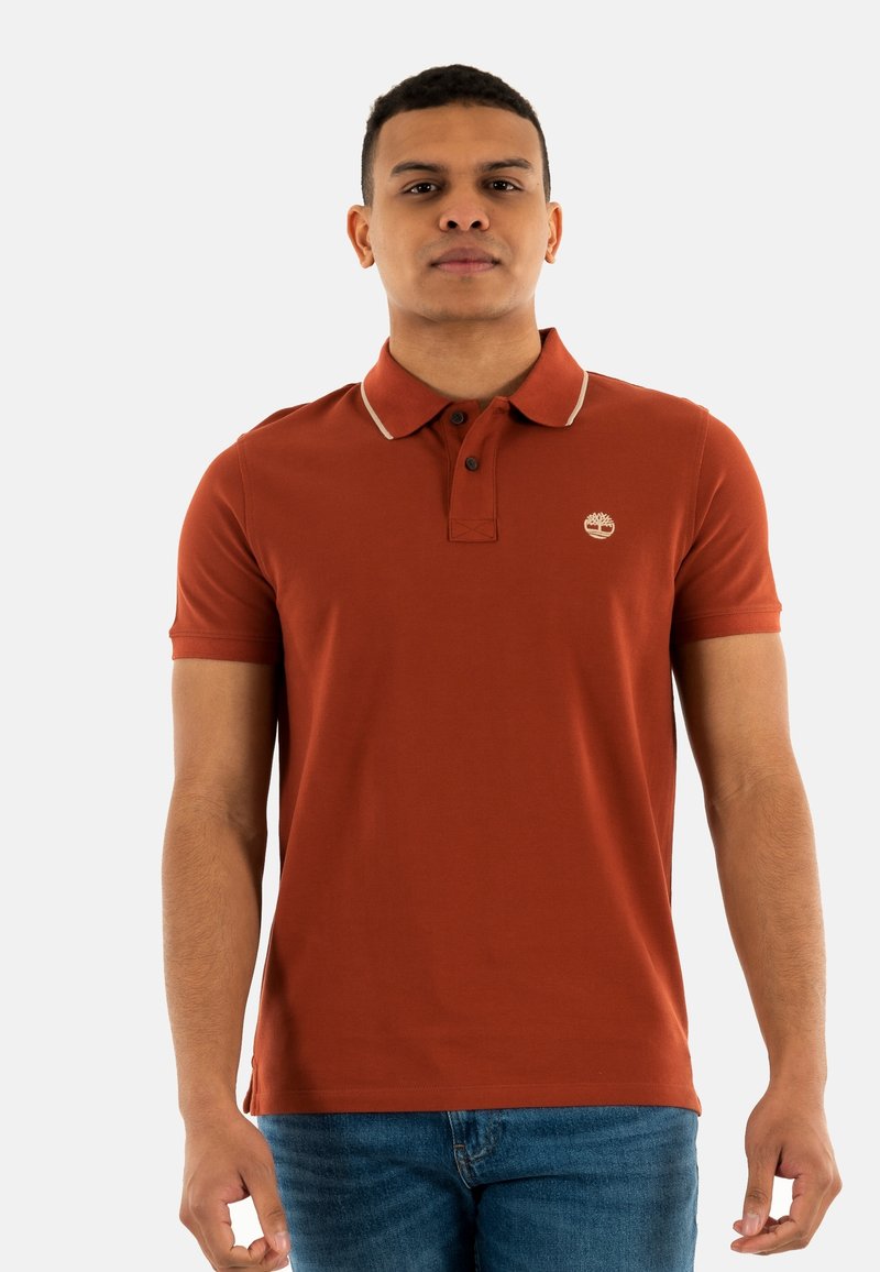 Polo rustico con colletto a contrasto, due bottoni e un piccolo logo. Realizzato in morbido cotone, presenta maniche corte e una forma fitted.