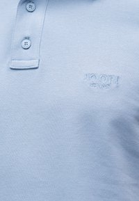 Ανοιχτό μπλε πικέ πόλο πουκάμισο με δύο κουμπιά και κεντημένο λογότυπο "JOOP! JEANS" στο στήθος.