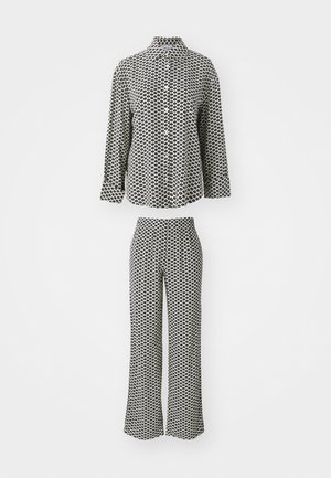 Svart- och vitt mönstrat pyjamaklädeset som består av en skjorta med krage och matchande utsvängda byxor. Tyget har en slät och lätt textur.
