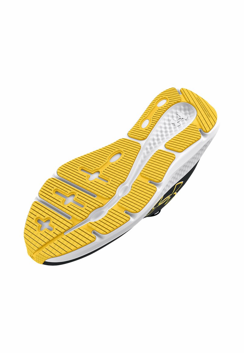 Schoenzool met een overwegend gele rubberen oppervlakte met getextureerde groeven. Zwarte accenten zichtbaar langs de buitenranden en het logo.