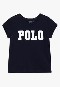 Marineblauwe katoenen t-shirt met korte mouwen; voorzien van grote witte blockletters die "POLO" over de borst spellen. Ronde hals.