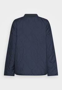 Giacca trapuntata blu navy con un motivo a onde testurizzato, colletto rialzato e maniche lunghe; tessuto liscio con una finitura leggermente lucida.