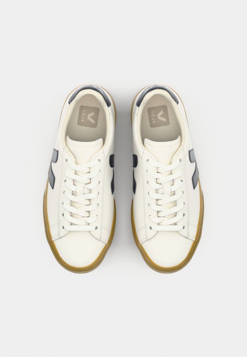 Baskets Veja blanches avec des accents gris, bout rond, lacets plats et semelle en caoutchouc naturel. Texture en cuir lisse et design minimaliste.