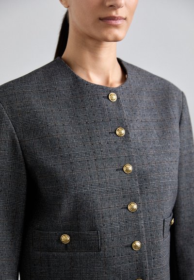 Grijze geblokte blazer van gestructureerde stof, met gouden knopen, een ronde halslijn en twee voorzakken met bijpassende hardware.