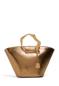 Goldfarbene metallische Tragetasche mit einem breiten, strukturierten Körper, der einen wellenförmigen Griff, einen abnehmbaren Charm und eine glatte, glänzende Textur aufweist.