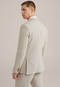 Hellbeige Anzugjacke mit einem dezenten Karomuster, ausgestattet mit einem einzelnen Schlitz, gezackten Revers und dekorativen Knöpfen an den Manschetten.