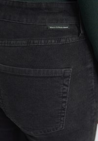 Must have seemne paksu, musta korgaku taktiga teksapüksid, millel on tagatasku ja väike "Marc O'Polo Denim" silt.
