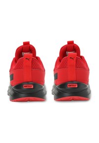 Chaussures de sport rouges avec une tige en maille, un col rembourré et des accents noirs. Comprennent une languette et un logo "SOFTRIDE" sur le talon.
