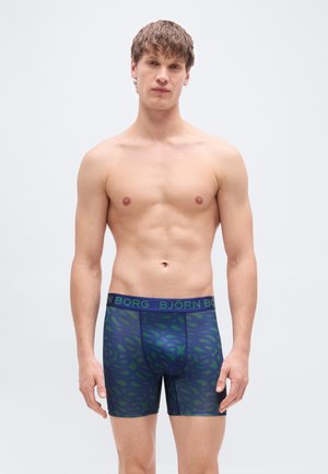 Caleçons boxer pour hommes en bleu foncé avec un motif de feuilles vertes, dotés d'une large ceinture élastique portant le texte "BJÖRN BORG" bien visible.