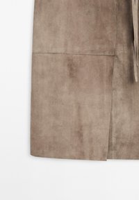 Light brown suede garment with a smooth texture, featuring a side slit and tied detail at the waist, highlighting the soft material.