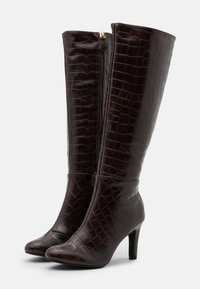 Bottes en cuir brun à motif crocodile, montantes jusqu'au genou, avec un bout pointu et un talon fin, dotées d'une fermeture éclair latérale et d'une texture lisse.