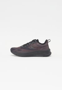 Black athletic shoe with a textured mesh upper, contrasting dark accents, and a thick rubber sole. Features laces and a rear pull tab.