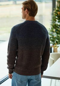 Pulover tricotat cu tiv și manșete ribbrate, având o nuanță gradată de la bleumarin închis la maro. Țesătura texturată conferă un aspect confortabil.