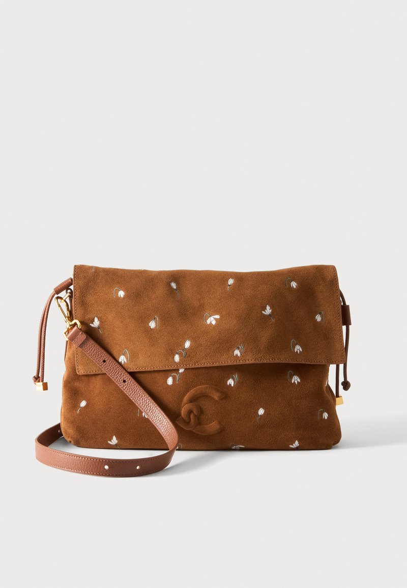 Καφέ τσάντα crossbody από σουέντ με μικρή λευκή κεντητή ανθοδέσμη και ρυθμιζόμενο δερμάτινο λουράκι, διπλωτό καπάκι με ανάγλυφο λογότυπο μπροστά.