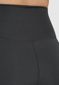 Leggings negros de cintura alta con una textura suave, que cuentan con costuras planas y una cinturilla ancha para mayor comodidad y soporte.
