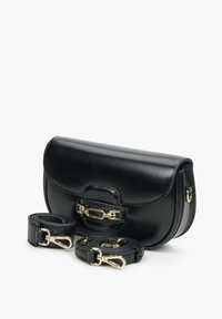 Czarna skórzana torba na ramię z zaokrągloną klapą, złotymi akcesoriami i podwójnymi odczepianymi paskami. Gładka tekstura i zorganizowany kształt.