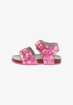 Sandalo rosa per bambini con motivi a cuori bianchi, due cinturini regolabili con fibbia, suola in sughero e soletta imbottita grigia.