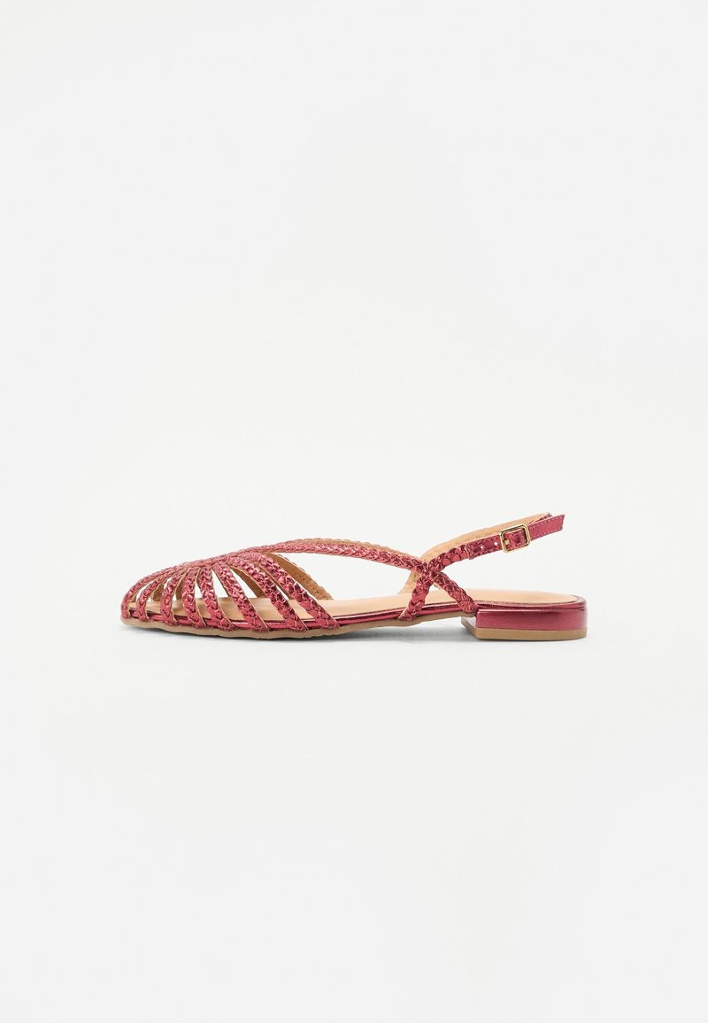 Sandale tissée rouge avec talon plat, bout ouvert et sangle de cheville ajustable avec boucle en métal. Doublure intérieure lisse et accents cousus.