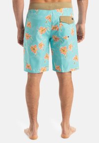Pánske plážové šortky svetlo tyrkysovej farby s kvetinovým vzorom v ružovej a žltej. Obsahujú béžový pás a zadnú vrecko so záklopkou.