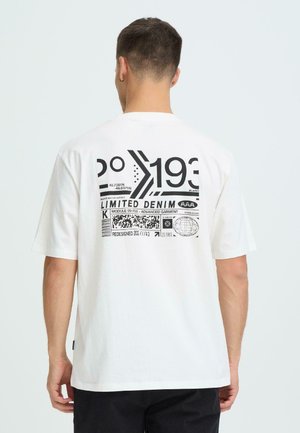 Witte T-shirt met zwarte grafische print op de achterkant, inclusief coördinaten, tekst en patronen, met korte mouwen en een ontspannen pasvorm.