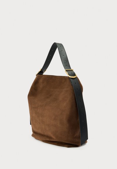 Mala de camurça castanha com uma alça larga e ajustável em couro preto, com detalhes em metal dourado. Textura suave; formato retangular e descontraído.