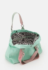 Mintgrünes Canvas-Tasche mit pinkem Schultergurt und Innenseite im Leopardenmuster; verfügt über Reißverschlüsse und einen Druckknopfverschluss an der Oberseite.