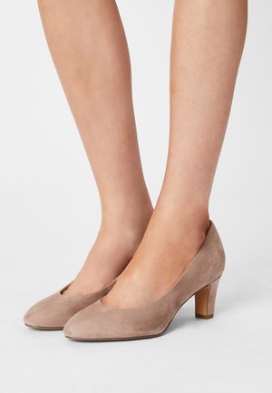 Escarpins en suede beige avec un bout arrondi et un talon carré de hauteur intermédiaire. Texture lisse et détail découpé à l'avant.